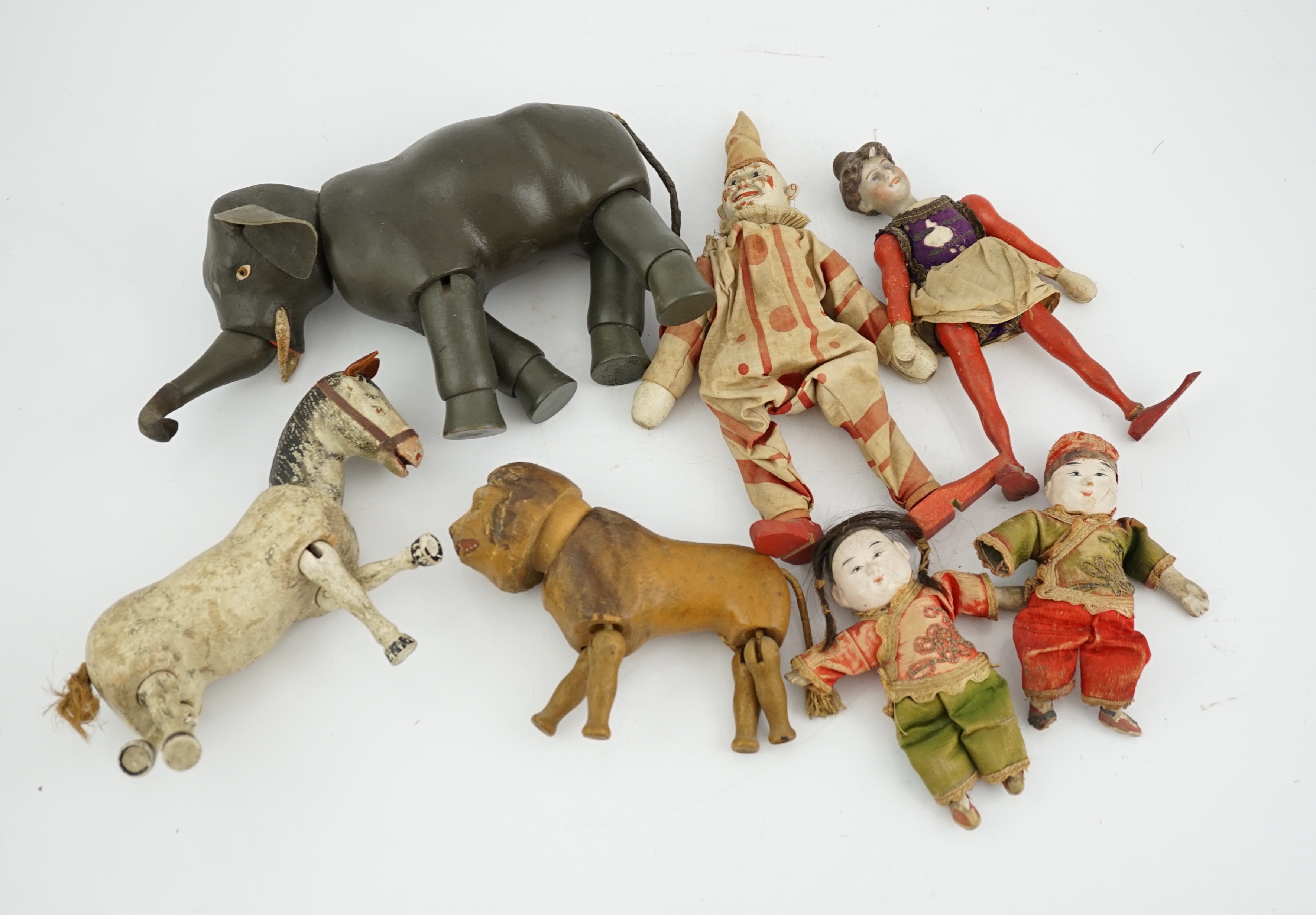 A Schoenhut Humpty Dumpty Circus, early 20th century, including elephant, lion house and other pieces, a playbarn (10) plus a peg doll and a German tinplate clockwork dog